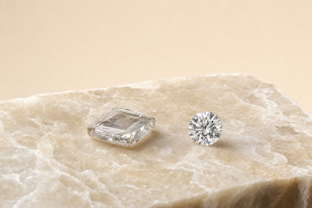 Diamant de synthèse brut à faces planes issu du procédé CVD, à côté du même diamant taillé en rond brillant, sur une pierre crème
